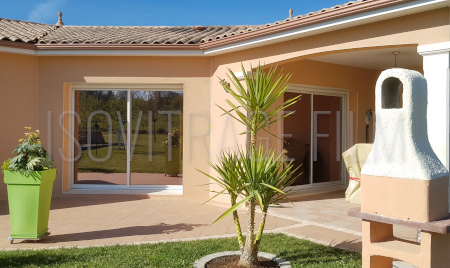 Illustration de l'utilisation d'un film de protection solaire réfléchissant de couleur bronze pour assortir le vitrage à la couleur du revêtement de la maison